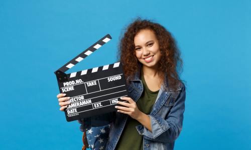 Jugendliche hällt eine Filmklappe in der Hand