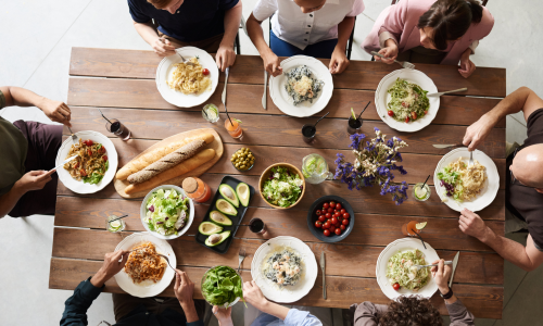 Ehrenamt macht FreuNde Gruppe Menschen sitzt an einem gedeckten Tisch beim gemeinsamen Essen